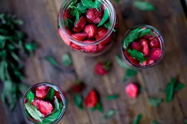 Strawberry mint infused water decorated in rustic style on dark wood table background — Stock Photo, Image