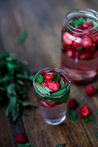 Aardbei munt geïnfundeerd water ingericht in rustieke stijl op donkere houten tafel achtergrond — Stockfoto