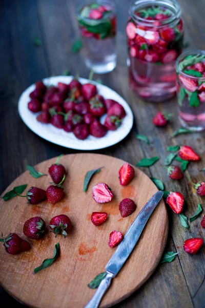 Aardbei munt geïnfundeerd water ingericht in rustieke stijl op donkere houten tafel achtergrond — Stockfoto