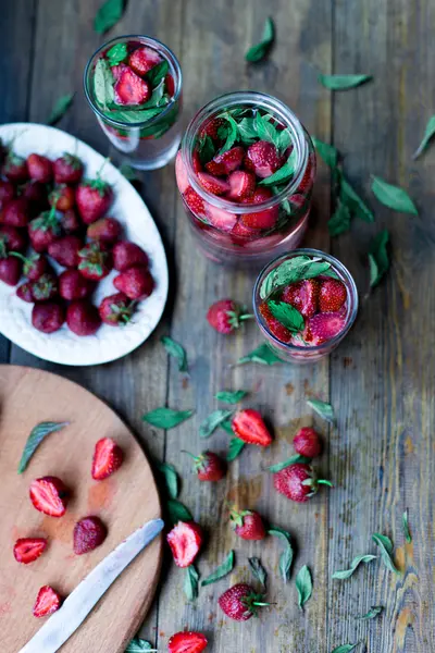 Aardbei munt geïnfundeerd water ingericht in rustieke stijl op donkere houten tafel achtergrond — Stockfoto