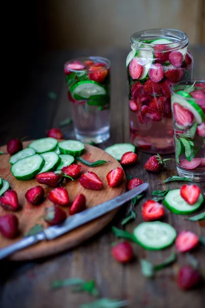 Strawberry mint cucumber infused water decorated in rustic style on dark wood table background — Stock Photo, Image