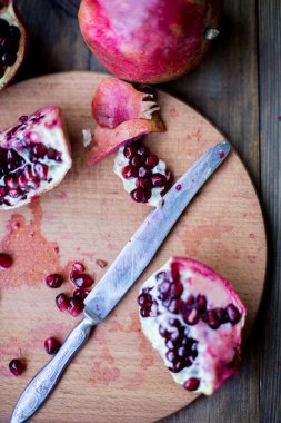 Organik nar açık kesme yarım ve tam bir ahşap masa koyu arka plan üzerinde rustik tarzda dekore edilmiş olan