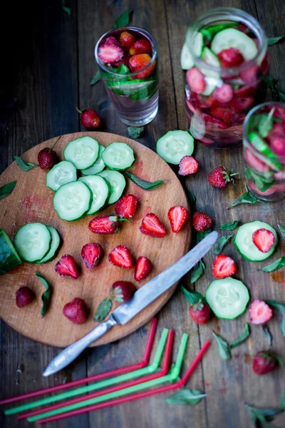 Strawberry mint cucumber infused water decorated in rustic style on dark wood table background — Stock Photo, Image