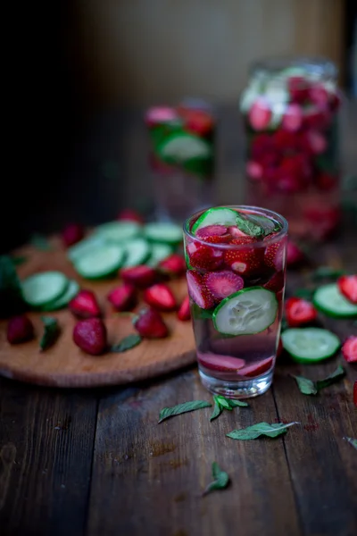 Strawberry mint cucumber infused water decorated in rustic style on dark wood table background — Stock Photo, Image