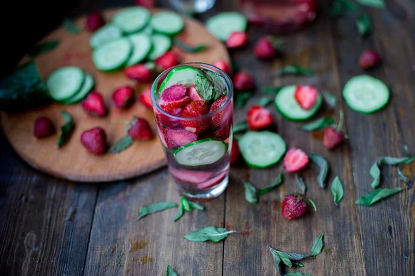 Fresa menta pepino infundido agua decorada en estilo rústico sobre fondo de mesa de madera oscura —  Fotos de Stock