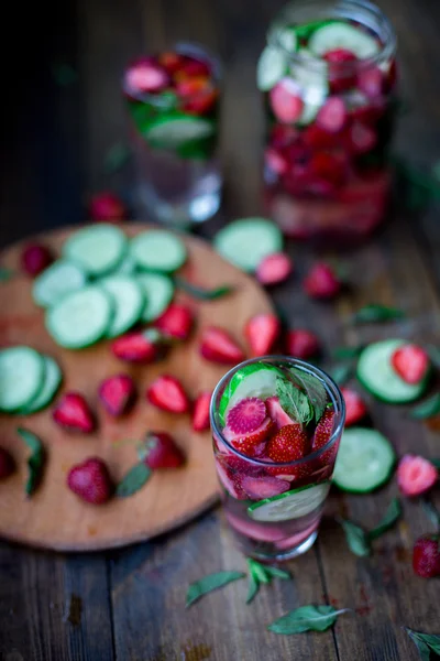 Strawberry mint cucumber infused water decorated in rustic style on dark wood table background — Stock Photo, Image