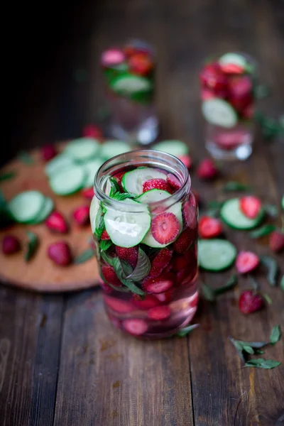 Strawberry mint gurka infunderas vatten inredda i rustik stil på mörka bord av trä bakgrund — Stockfoto