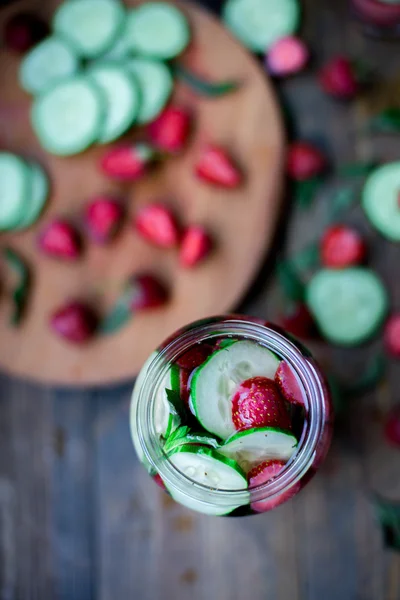Strawberry mint gurka infunderas vatten inredda i rustik stil på mörka bord av trä bakgrund — Stockfoto