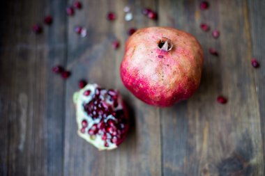 Organik nar açık kesme yarım ve tam bir ahşap masa koyu arka plan üzerinde rustik tarzda dekore edilmiş olan