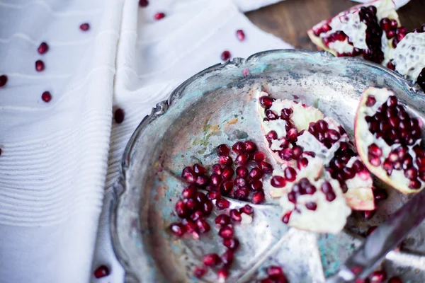 Organic pomegranate open cut in half and full one on a wooden dark table background decorated in rustic style — Stock Photo, Image