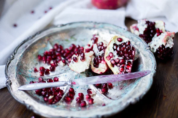 Organiczny owoc granatu wykop otwarty na pół i pełne jeden na tle drewniany stół ciemny urządzone w stylu rustykalnym — Zdjęcie stockowe