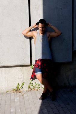 gülümseyen ve having fun dışında inanılmaz yaz gün boyunca kentin ile poz bir şapka giyen serin genç ve yakışıklı beyaz esmer hipster patenci adam