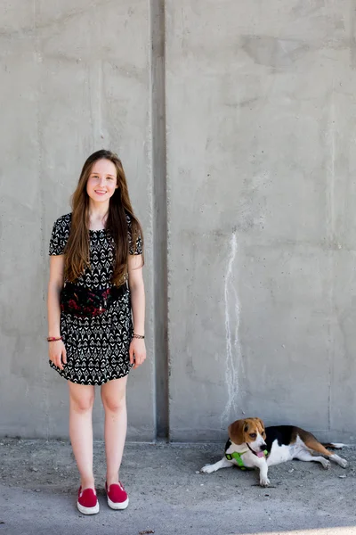Retrato de fresco jovem e bonito caucasiano adolescente loira hipster menina com longo lindo cabelo está posando sorrindo e se divertindo com seu cachorro beagle — Fotografia de Stock
