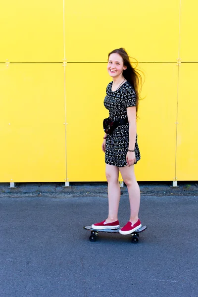 Legal jovem e bonito caucasiano loira adolescente hipster skatista menina com longo lindo cabelo está posando sorrindo e se divertindo fora enquanto patina com ela bonito pouco skate durante incrível verão dia — Fotografia de Stock