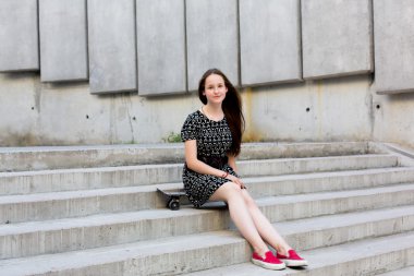 uzun muhteşem saçlı güzel genç ve güzel beyaz sarışın genç hipster patenci kız gülümseyerek ve şaşırtıcı yaz gündüz ile onun sevimli küçük paten buz pateni süre dışarıda eğleniyor poz