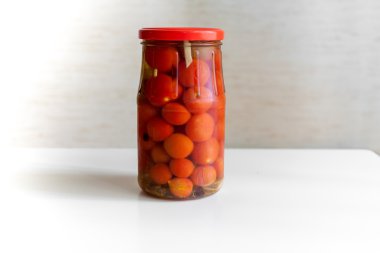 Cam beyaz zemin üzerine domates korur.
