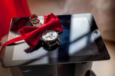 Düğün damat aksesuarları kırmızı renkte. Kravat-kelebek, izlemek, tablet.