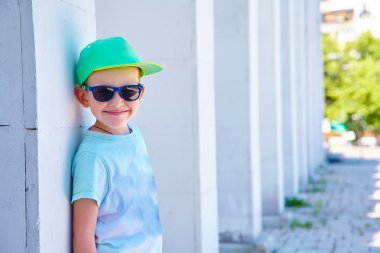 Şık küçük çocuk güneş gözlüğü ve şapka. Çocukluk. Yaz Zamanı.