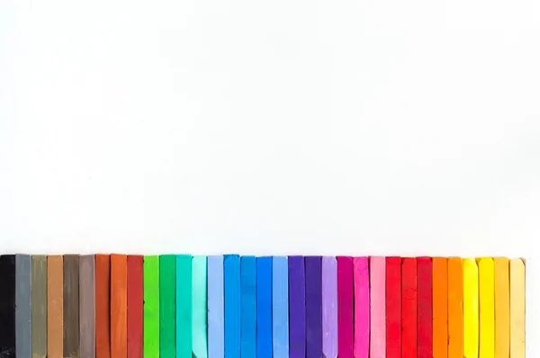 Giz coloridos alinhados em fundo branco — Fotografia de Stock