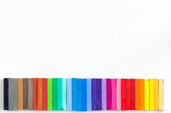 Colorful chalks lined up on white background — Stock Photo, Image