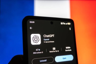 Fransa bayrağı önünde akıllı telefondaki ChatGPT uygulaması.