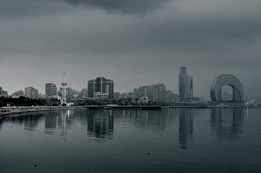 Kasvetli bir gökyüzü altında Bakü 'nün dramatik şehir manzarası cesur mimari, canlı şehir enerjisi ve Azerbaycan başkentinin dinamik ruhunu sergiliyor..