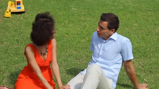 Love couple sitting on the grass — Stock Video