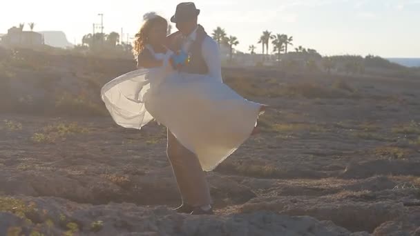 Brudparet kysser vid solnedgången — Stockvideo