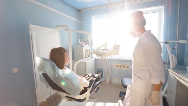 Vrouwelijke tandarts werkt bij haar patiënten tanden — Stockvideo