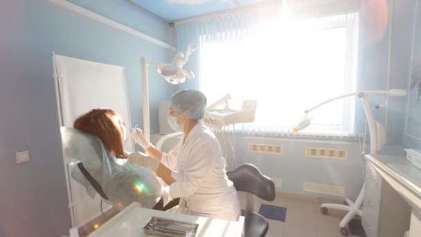Vrouwelijke tandarts werkt bij haar patiënten tanden — Stockvideo