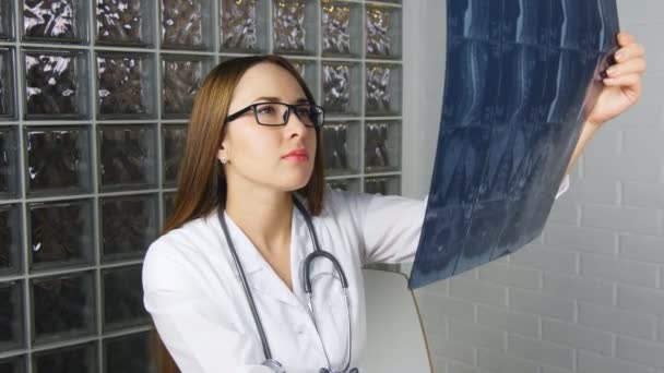 Jeune et gentil médecin regarder un patient radiographie à l'hôpital — Video