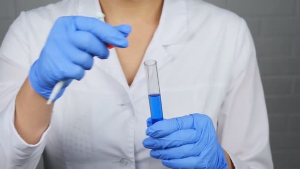 Um cientista olha para uma amostra de um produto químico em um laboratório — Vídeo de Stock