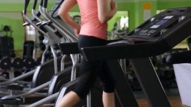 Bir koşu bandı üzerinde çalışan çekici genç kadın