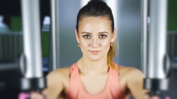 Mujer haciendo entrenamiento físico en una máquina de mariposas con pesas en un gimnasio — Vídeos de Stock