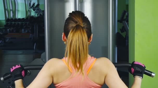 Mulher fazendo treinamento de fitness em uma máquina de borboleta com pesos em um ginásio — Vídeo de Stock