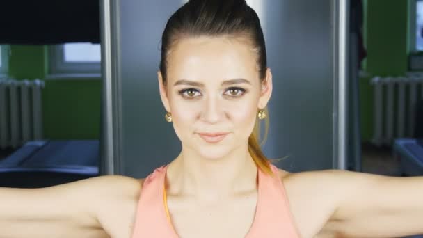 Femme faisant de l'entraînement physique sur une machine à papillons avec des poids dans une salle de gym — Video