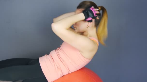 Jeune fille athlète entraîne la presse, faire des exercices sur le fitball — Video