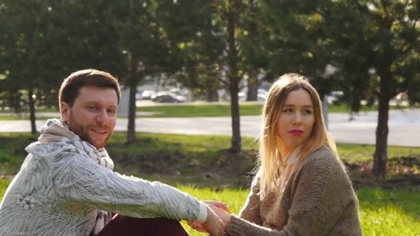 Young couple sitting in park — Stock Video