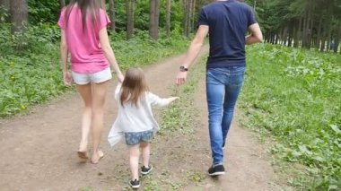 Parkta ailesiyle yürüyen tatlı bir kız bebek.