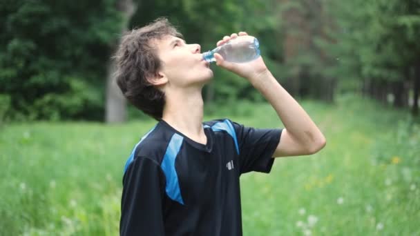 Man drinkwater in de zomer bos — Stockvideo