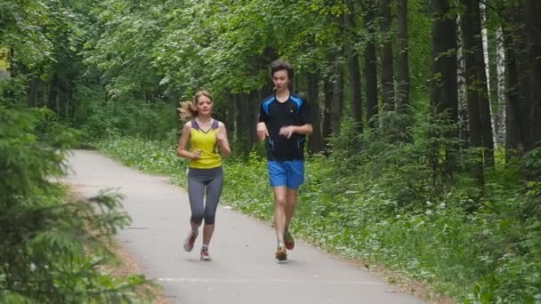 Szczęśliwa para joggingu w parku, w zwolnionym tempie — Wideo stockowe