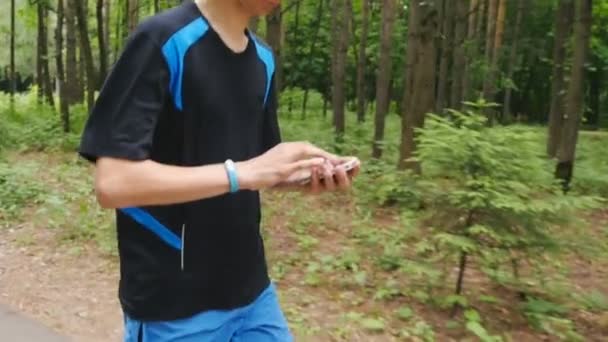 Junger Mann mit Fitnessarmband beim Morgenlauf — Stockvideo