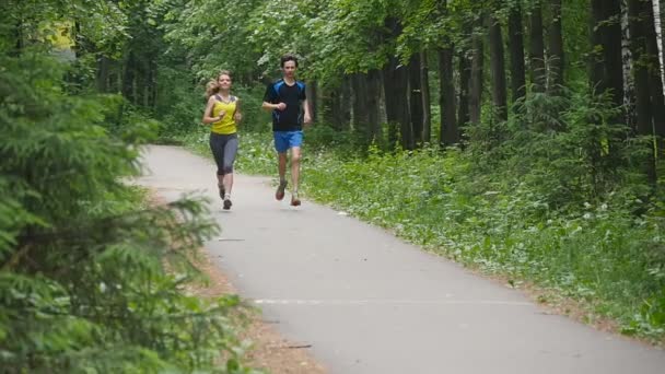 Szczęśliwa para joggingu w parku, w zwolnionym tempie — Wideo stockowe