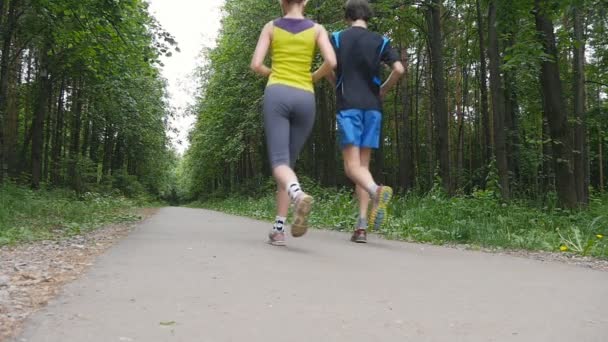 幸せなカップルの公園、スローモーションでジョギング — ストック動画