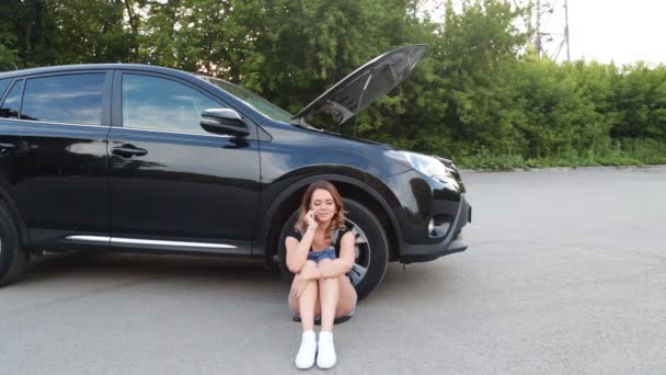 Όμορφη κοπέλα κλήση κινητό τηλέφωνο κοντά το αυτοκίνητό της σπασμένα — Αρχείο Βίντεο