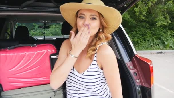 Дівчина в багажнику автомобіля з валізами — стокове відео