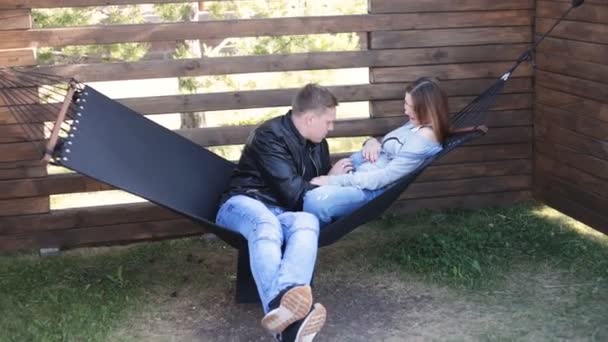 Junges Paar auf Hängematte, das ein Herz auf seinem bald Kind erschafft. — Stockvideo