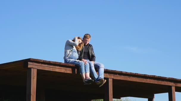 Verliebtes Paar sitzt auf dem Dach — Stockvideo