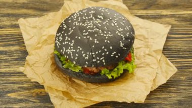 Ahşap masa üzerinde siyah burger