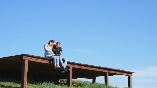 Закохана пара сидить на даху — стокове відео